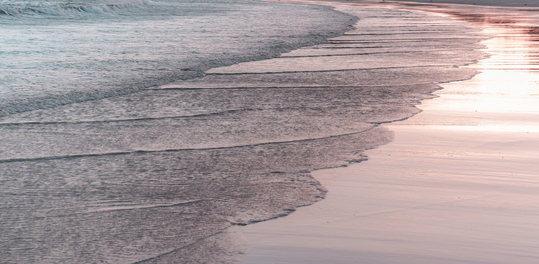 foamy sea washing sandy beach in evening